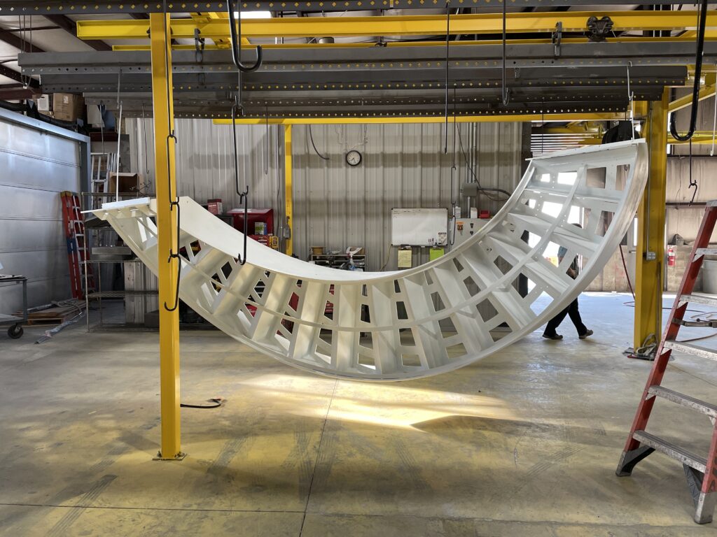 curved staircase hanging in warehouse, drying from white powder coating